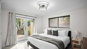 Una camera da letto con un letto, una finestra, un comodino e una ventola a soffitto.