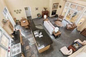 A spacious living area with a kitchen, dining table, and seating arrangements. - Bailey's Beach Retreat | Easy Access to Lake Michigan (Muskegon)