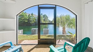 Eine überdachte Terrasse mit Seeblick, Klimaanlagen und Gartenmöbeln.