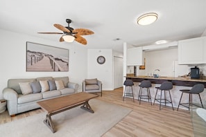 A modern living room with a sofa, coffee table, and a ceiling fan.