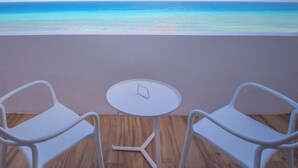 A balcony with two white chairs and a small round table, overlooking a clear blue sea. - Exclusive Pent House, stunning ocean and lagoon views (Cancún)