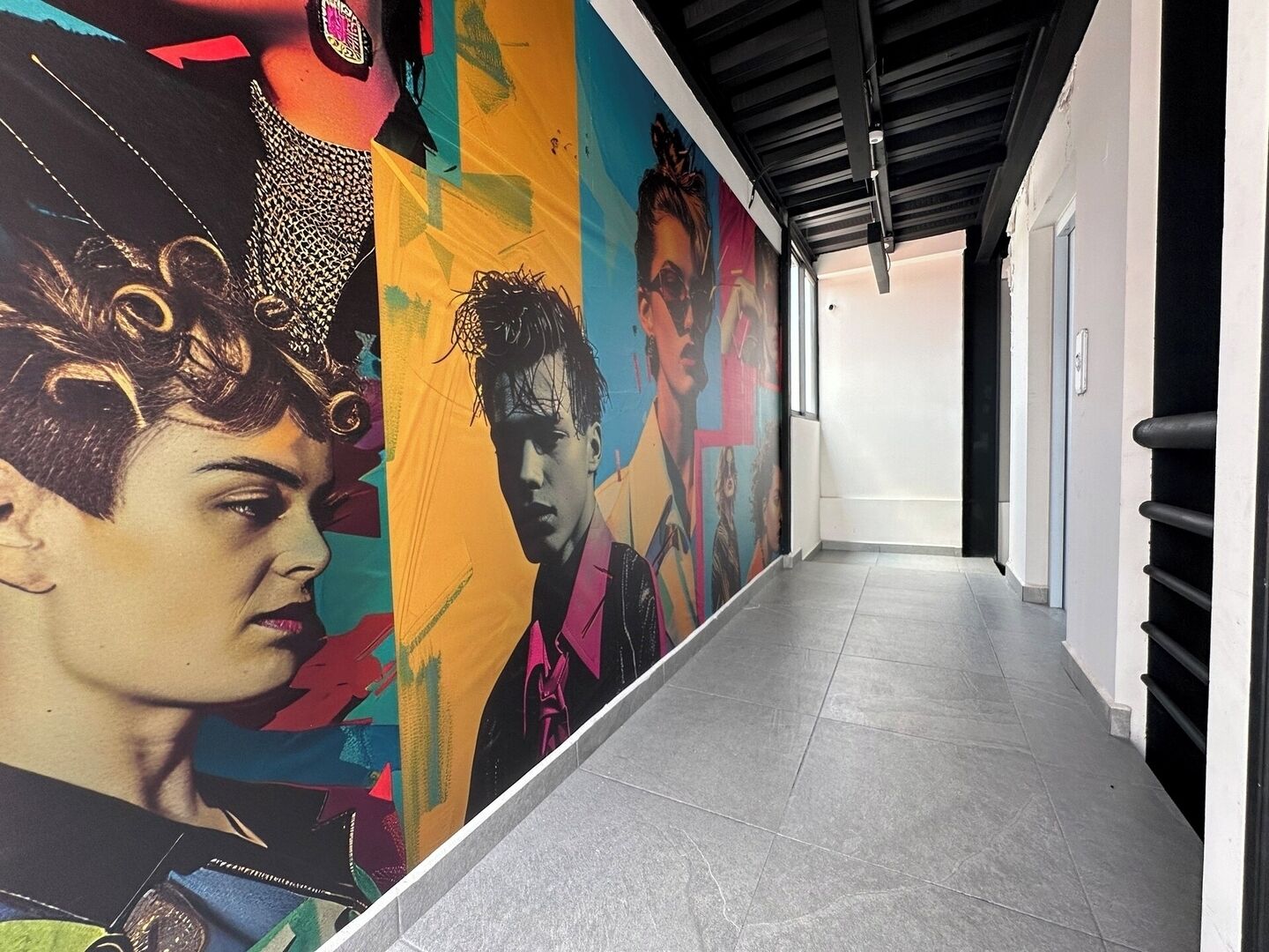 A hallway with a vibrant mural featuring multiple portraits.