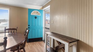 A dining area with a wooden table and chairs, a turquoise door, and a view of the outside. - Affordable, Private, Single Level House Steps From Hard Rock Casino Pet Friendly (Bristol)