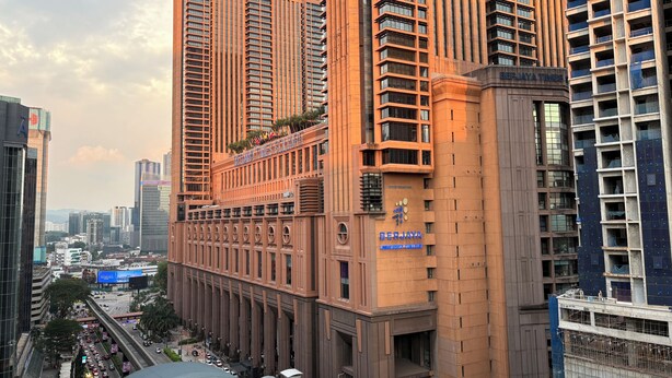 Un edificio de varios pisos con un cartel llamativo de 'BERJAYA University College'.