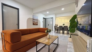 Una sala de estar moderna con un sofá, una mesa de centro y un comedor con sillas y una mesa.