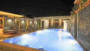 A swimming pool area with lounge chairs and a water feature. - Golden Bayon Boutique Hotel (Siem Reap)