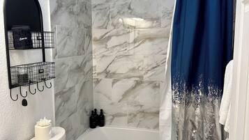 Ein Badezimmer mit Badewanne, Toilette und Duschvorhang.
