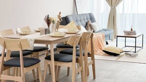 A modern living room with a dining area, featuring a grey sofa, wooden dining table, and chairs. - MH Maison by Manhattan Group  (Kuala Lumpur)