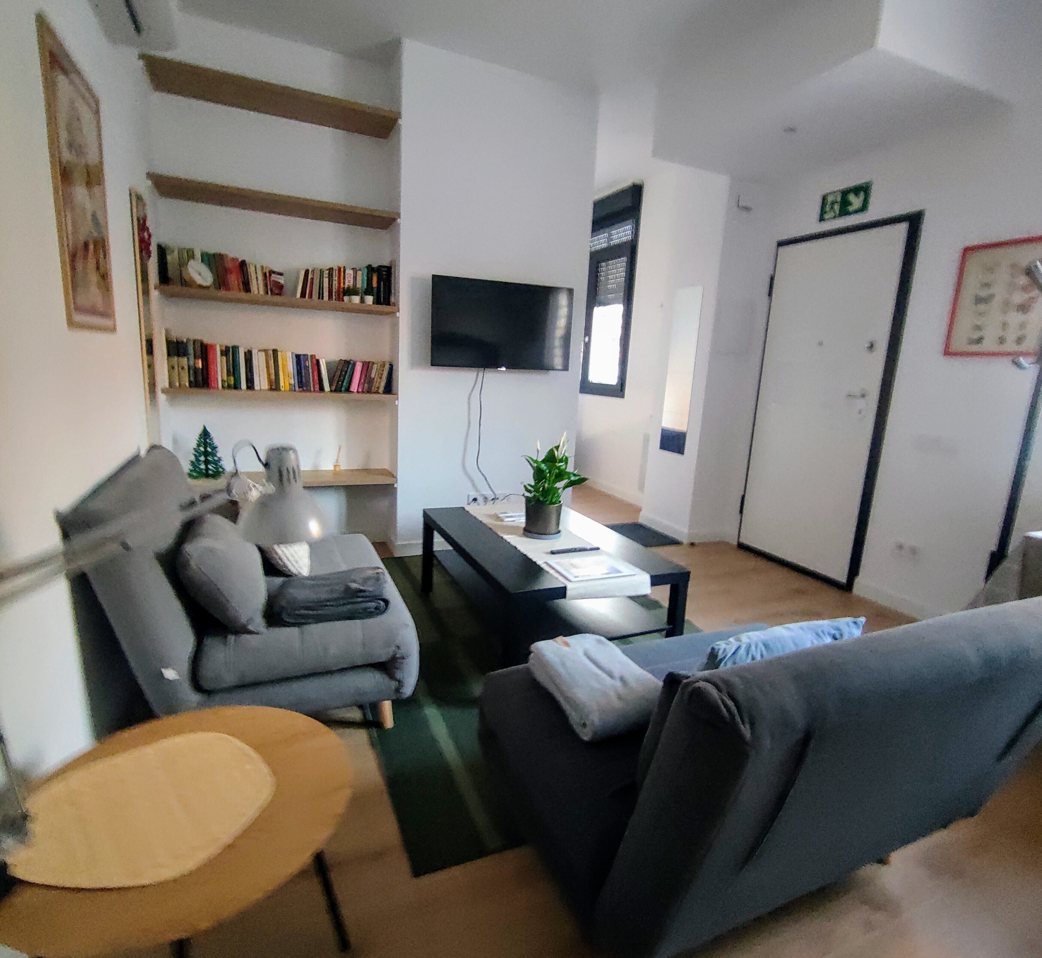Uma sala de estar moderna com um sofá, uma mesa de centro e uma estante.