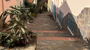 A narrow stone pathway leading to a staircase in a residential area with buildings on either side. - Mobile Home 'Chez Sylvie' with Shared Pool, Wi-Fi, and Air Conditioning (Argelès-sur-Mer)