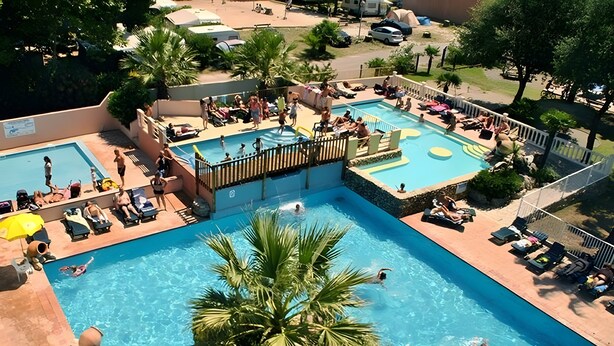 A multi-level outdoor swimming pool with various seating areas and palm trees. - Mobile Home 'Chez Sylvie' with Shared Pool, Wi-Fi, and Air Conditioning (Argelès-sur-Mer)