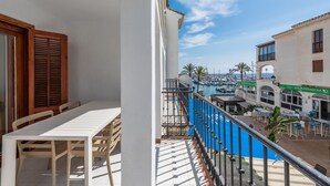 A balcony with a view of a marina and a restaurant named "The Quays Irish Bar". - Chanquete 2310  One Bedroom (Manilva)