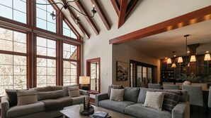 A spacious living room with large windows, a fireplace, and a cozy seating area. - HOT TUB - Ping-Pong - BBQ Terrace - Free Shuttle (Mont-Tremblant)
