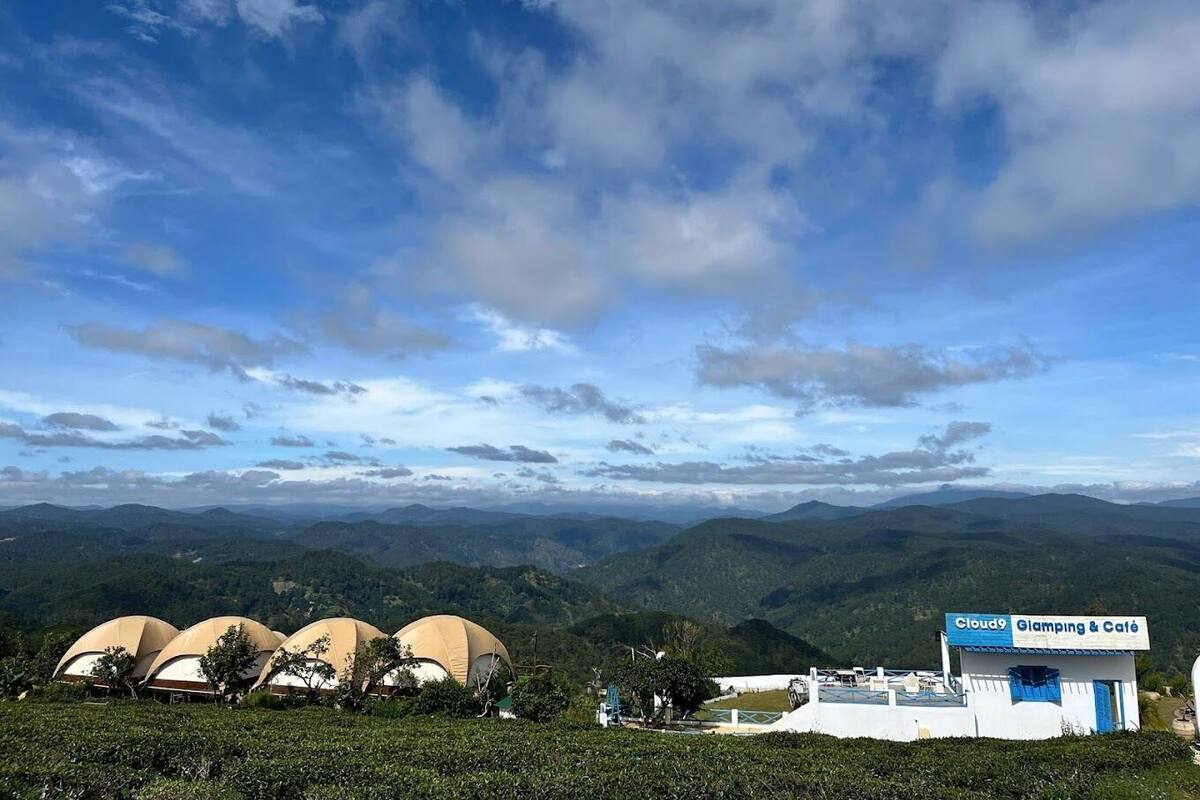 A view of a mountainous landscape with several dome-shaped structures and a building labeled "Cloud9 Glamping & Café".