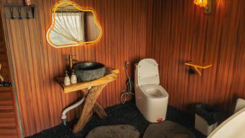A wooden bathroom with a rustic design, including a wooden sink, a toilet, and a mirror with a unique shape.