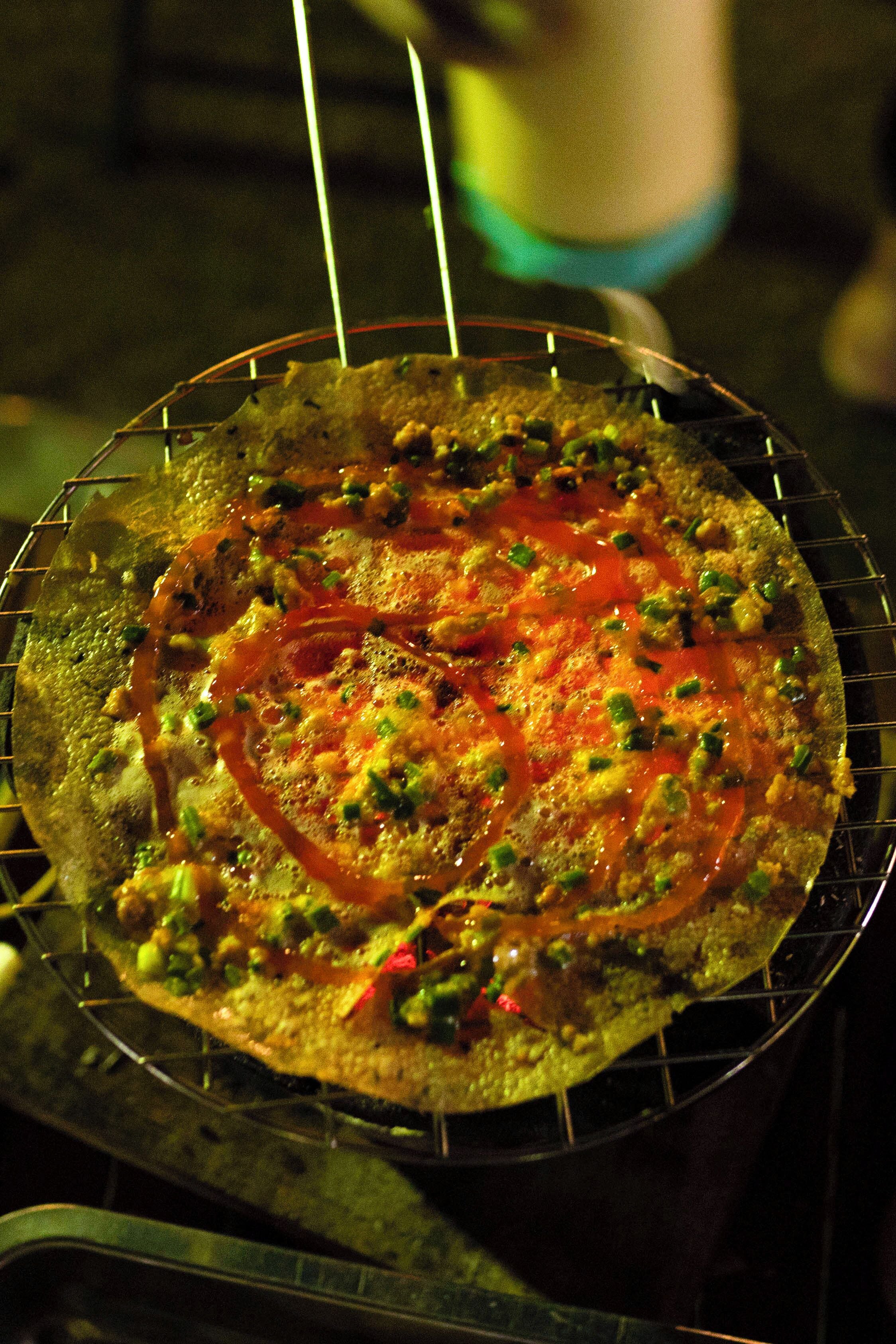 A pizza on a wire rack.