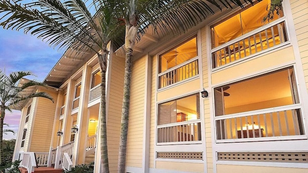 Un edificio de dos pisos con varias ventanas y un balcón.