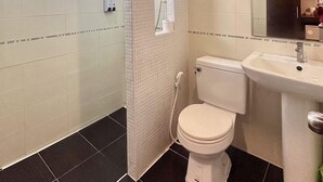 A modern bathroom with a toilet, sink, and shower area. - The leaf&pool hostel (Koh Lan)