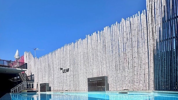 A swimming pool with a bamboo wall and a clear blue sky. - The leaf&pool hostel (Koh Lan)