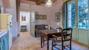 A cozy room with a wooden table, chairs, a sofa, and a window with a view of trees. - Marruca by Interhome (Castiglioncello)