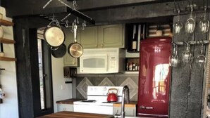 A kitchen with a wooden island, stools, a stove, a microwave, and hanging pots. - ★★Ski In-Out! Mid-Mountain PALISADES home! Hot tub! Views! Walk to village! ★★ (Olympic Valley)