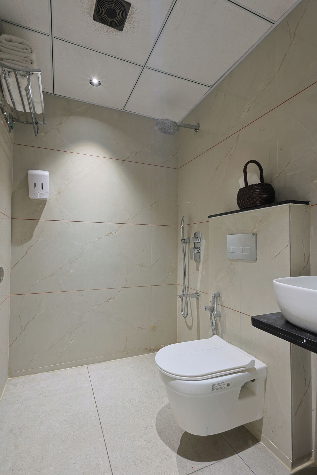 Un baño moderno con inodoro, lavamanos y ducha.