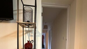 A black metal shelving unit with three shelves, each holding a different object.