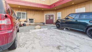 Un edificio con un garaje y dos coches estacionados afuera.