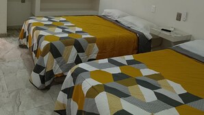 A room with two beds, a desk, and a window with curtains.