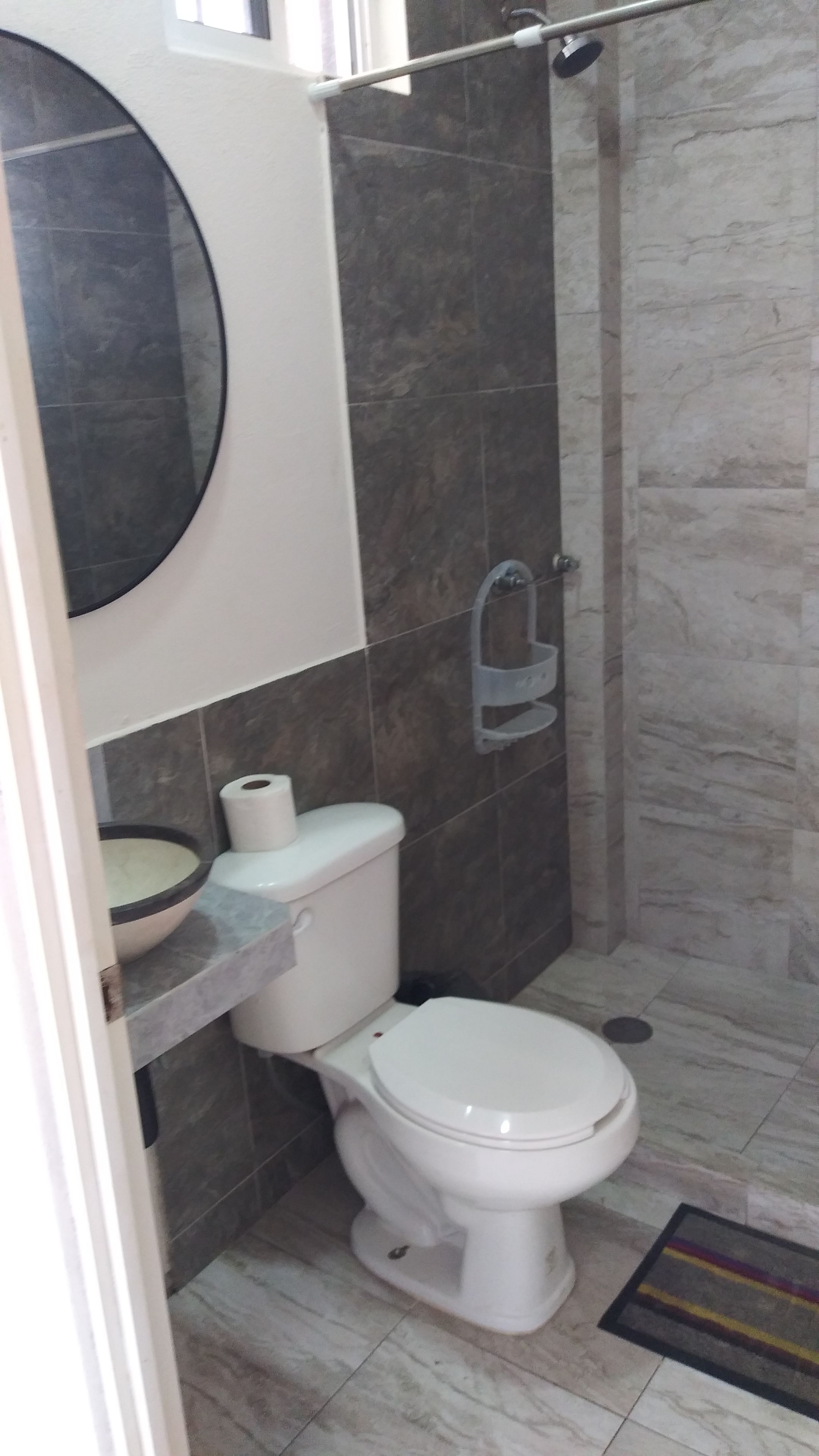 Un baño con inodoro, ducha y lavamanos.