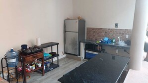 A compact kitchen with a gas stove, a refrigerator, and a sink.