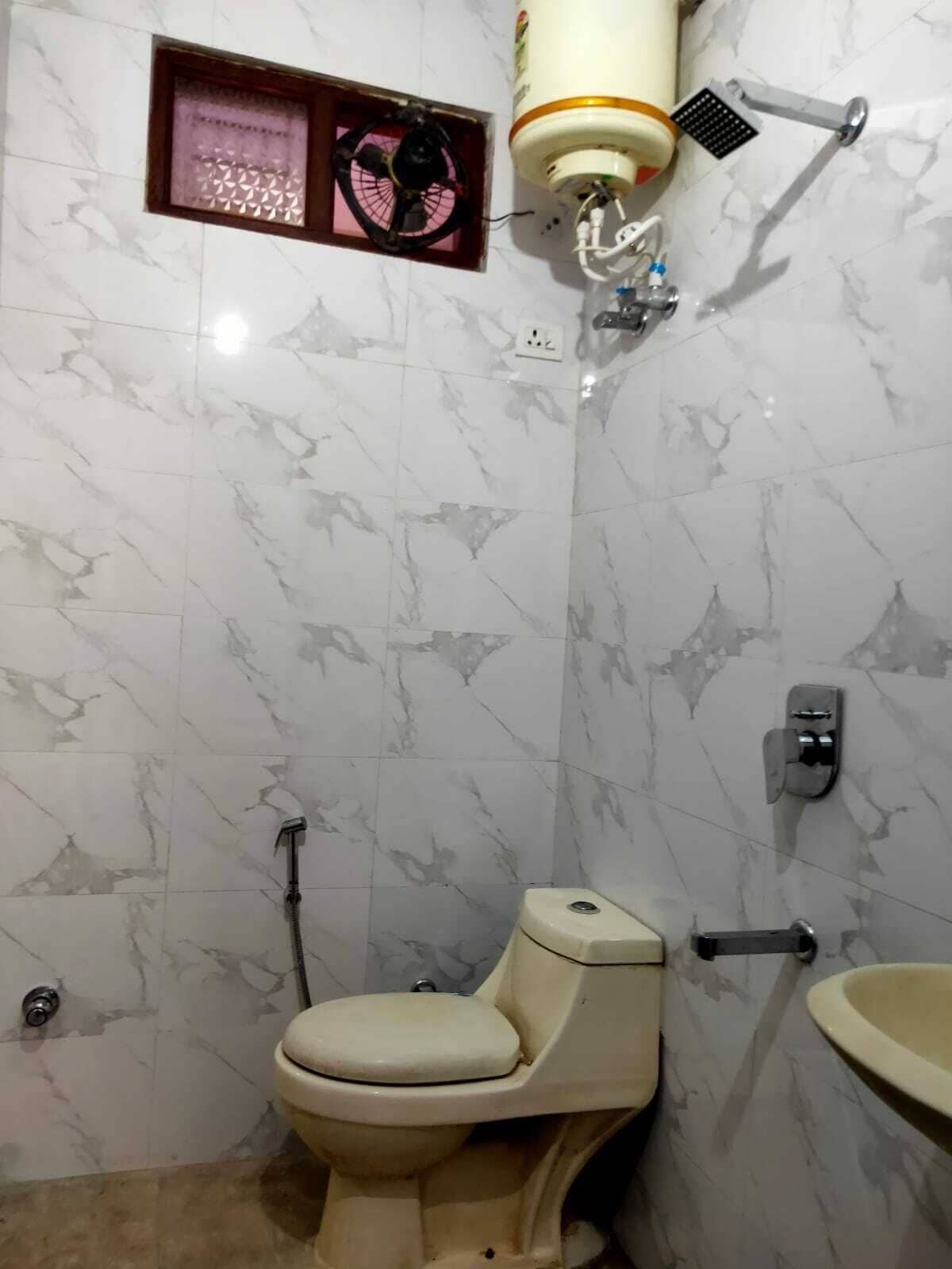 A bathroom with a toilet, a sink, and a shower.