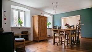 A dining area with wooden furniture, a cabinet, and potted plants.