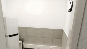 Une petite cuisine équipée d’un réfrigérateur, d’un évier et d’un plan de travail.