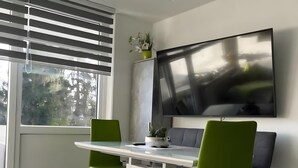 Un espace repas moderne comprenant une table, des chaises et un téléviseur.
