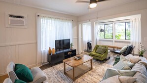 A living room with a television, sofa, armchair, and a coffee table. - Island Oasis Near Waterfalls and Hilo`s Markets (Hilo)