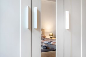 Une chambre à coucher avec un lit, une table de chevet et une lampe.