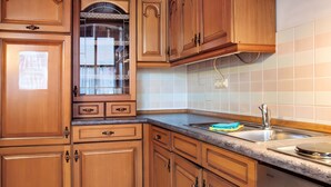 A kitchen with wooden cabinets, a stainless steel sink, and a dishwasher. - Holiday Apartment 'Alte Stadtmauer' with Shared Garden and Wi-Fi (Bamberg)
