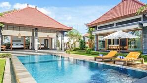 A modern resort with a swimming pool, lounge chairs, and a well-maintained garden. - Srimalen Villa by Kozystay - Canggu- (Canggu)