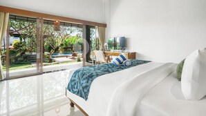 A modern bedroom with a large bed, a desk, and a TV. - Srimalen Villa by Kozystay - Canggu- (Canggu)
