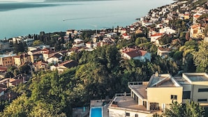 Una zona residencial costera con casas, una piscina y vista al mar.