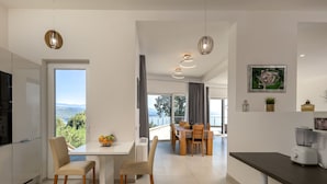 Una cocina moderna con comedor, ventanas amplias y vistas al exterior.