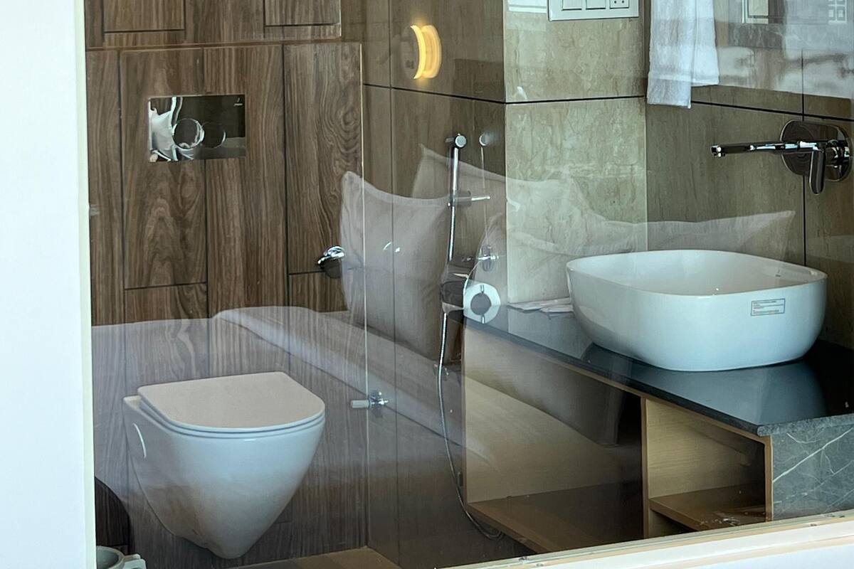 Un baño moderno con ducha acristalada, inodoro y lavamanos.