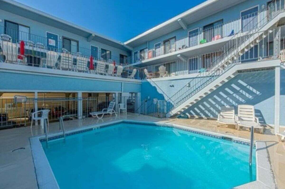 Ein Hotel mit Pool, Außenbereich und einer Treppe, die zu den oberen Stockwerken führt.