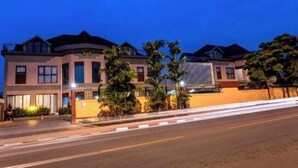 A multi-story hotel with a modern architectural design, featuring a prominent entrance and a well-lit facade. - Legend Hotel (Kigali)