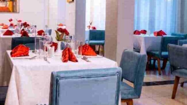 A dining area with tables set for service, featuring a modern interior design with light-colored walls and ceiling. - Legend Hotel (Kigali)