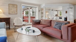 Ein modernes Wohnzimmer mit einem roten Sofa, einem weißen Couchtisch und einem Holzboden.