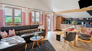 Ein modernes Wohnzimmer mit Sofa, Couchtisch und Essbereich.
