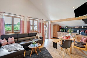 A modern living room with a sofa, coffee table, and dining area.