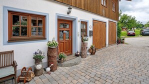 Ein Gebäude mit Holzfassade, einer Haustür und einem gepflasterten Auffahrt.